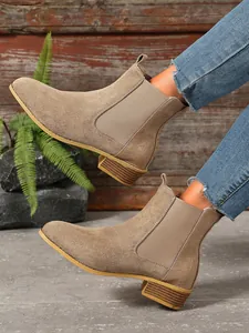 Detailed view of khaki matte leather Chelsea boots with crocodile texture panel