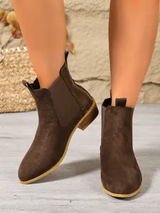 Close-up of stylish brown faux suede Chelsea boots with chunky heel and model view.