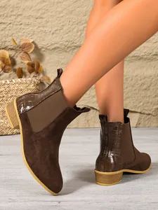 Close-up detail of women's brown Chelsea boots featuring mixed suede and croc texture