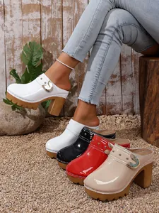 Stylish women's high heel platform clogs featuring decorative rivets and patent leather.