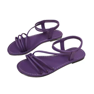 Elegantes sandalias planas moradas con múltiples tiras finas y correa elástica trasera.