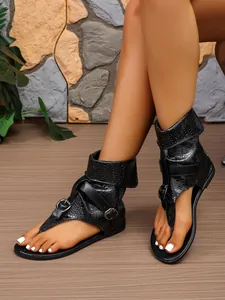 Detailansicht der schwarzen hohen Zehentrenner-Sandalen mit Schnallen