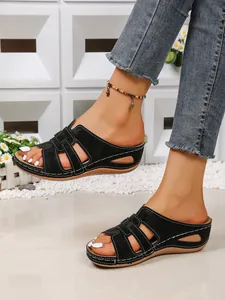 Vue rapprochée de sandales compensées noires pour femmes avec design ajouré et surpiqûres