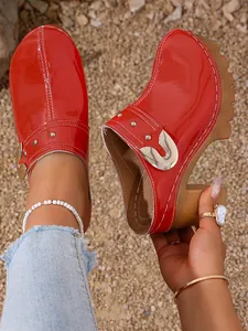 Fashionable red patent leather platform clogs with rivets and chunky high heel detail