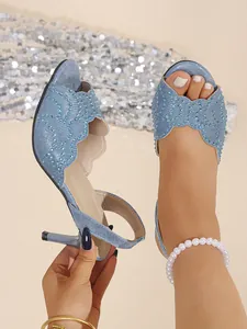 Detailansicht hellblauer Stiletto-Sandalen mit Glitzer-Finish und funkelnden Strasssteinen