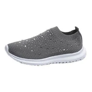 Graue Fly-Knit Slipper für Damen mit funkelndem Strassbesatz und weißer Sohle.