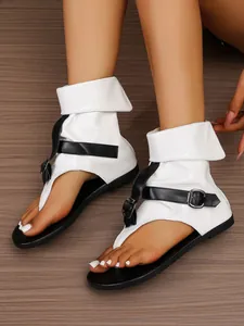 Weiße High-Top-Zehentrenner-Sandalen mit Schlangenmuster, schwarzen Riemen und flacher Sohle.