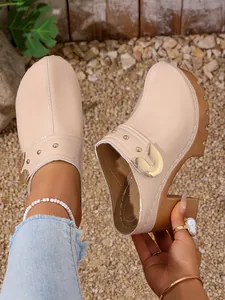Detail view of nude patent leather high heel clogs with rivet and platform