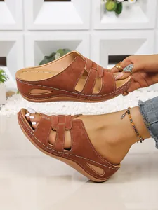 Gros plan sur des sandales compensées marron pour femmes avec coutures blanches