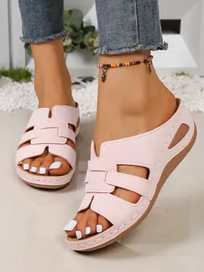 Détail rapproché de sandales compensées roses pour femmes avec découpes et coutures