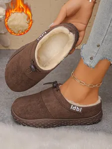 Detail of brown suede clogs with thick warm cream faux fur lining.