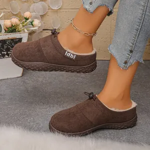 Close-up of brown suede-like clogs with warm faux fur lining and drawstring detail