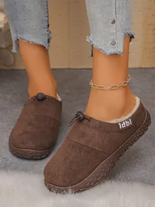 Close-up of brown suede slip-on shoes with toggle drawstring and plush lining