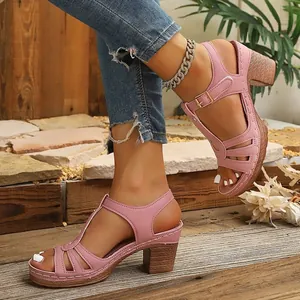 Détail rapproché de sandales à talons roses élégantes avec lanières et boucle dorée