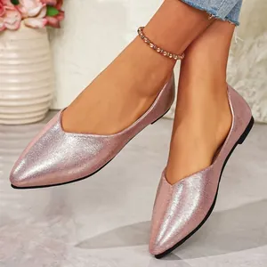 Detailed close-up of pink metallic pointed-toe ballet flats with shimmer finish texture