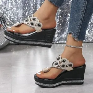 Elegantes sandalias de cuña negras con detalles florales de encaje y pedrería