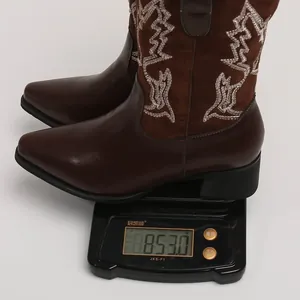 Vue détaillée montrant la mesure du poids de bottes western marron brodées de fleurs