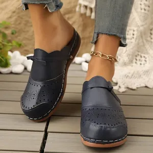 Elegant navy blue cutout clogs with bow detail and floral pattern design for stylish women