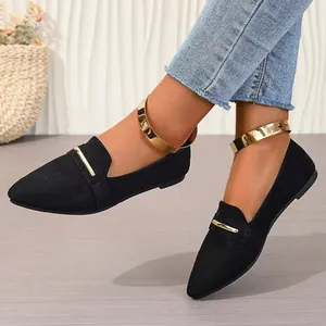 Stylish black pointed-toe flat shoes featuring a decorative gold ankle cuff and metal bar.