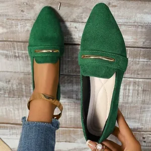 Close-up of green suede pointed-toe loafers with elegant gold metal bar detail