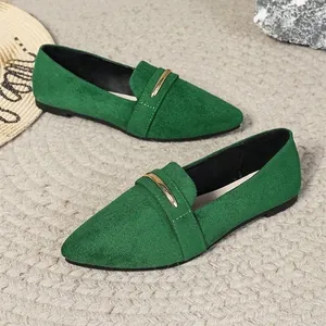 Detailed view of green suede loafers with elegant gold metallic buckle and pointed toe