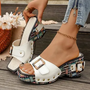 Detailweergave van deze witte sleehak sandalen met kleurrijk geweven plateau en klinknagels