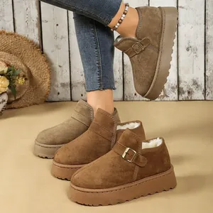 Primer plano de botas de nieve marrones con plataforma, forro de felpa y hebilla de moda