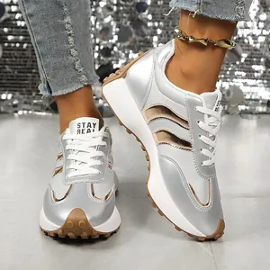 Stilvolle silberne Metallic-Sneaker mit dicken Sohlen und weißen Schnürsenkeln