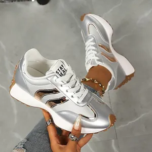 Nahaufnahme von silbernen Metallic-Sneakern mit roségoldenen Akzenten und Profilsohle