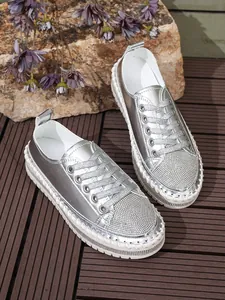 Silver metallic sneakers with sparkling rhinestone toe and white braided sole detail.