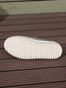 Detail view of serrated white platform sole on silver metallic fashion shoe size 37