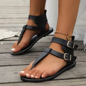 Stylish black T-strap gladiator sandals featuring gold buckle straps and lock anklet detail