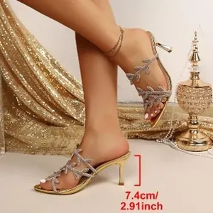 Eleganti sandali dorati con cinturini a foglia e tacco a spillo da 7,4 cm di altezza.