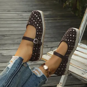 Detailed view of brown studded Mary Jane flats on a rustic wooden deck
