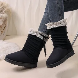 Detailed view of women's black boots featuring elegant white lace trim and bow ribbon details