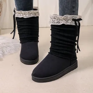 Black winter boots with white lace trim and ribbon bows, shown being worn by a model