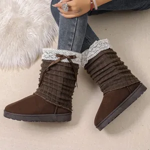 Close-up detail of brown winter boots featuring ribbed knit sleeves and white lace trim