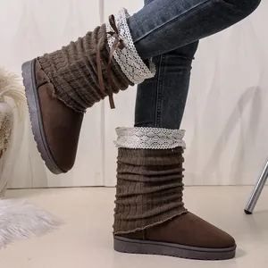 Detailed view of brown winter boots with knitted slouchy cuffs and white lace trim.