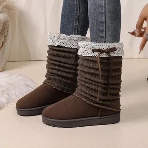 Detail showing brown snow boots with knitted cuffs, white lace trim and cute bows