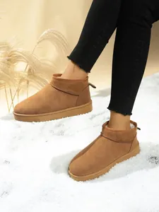 Classic brown suede snow boots for women with cozy faux fur lining on a white winter snow background