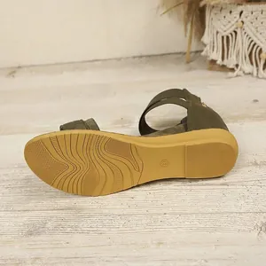 Macro view of the non-slip rubber sole on army green bohemian women's flat sandals