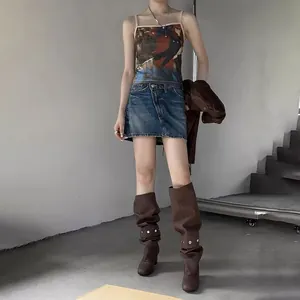 Fashionable outfit with printed camisole, denim skirt, and brown leather boots