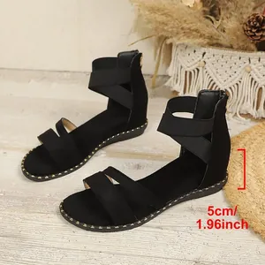 Detail view of black wedge sandals with 5cm heel height and elastic straps