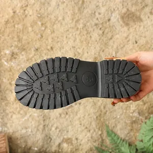 Close-up macro view of the black non-slip lugged rubber sole on platform footwear