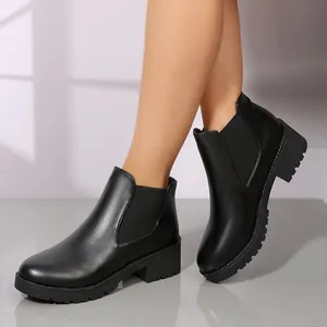 Vista detallada de elegantes botines Chelsea negros con elástico lateral y tacón bloque
