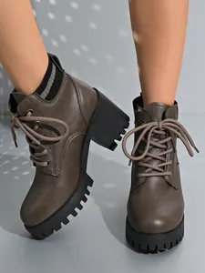 Close-up view of women's taupe lace-up chunky heel ankle boots with a rugged platform sole.