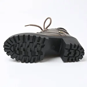 Detailed bottom view of durable non-slip lug sole on brown chunky heel ankle boot