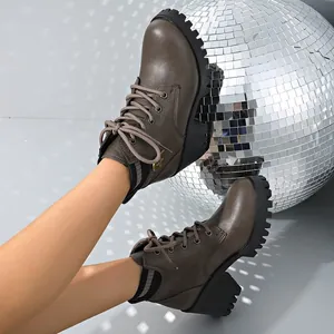 Detail shot of brown chunky platform ankle boots with disco ball prop