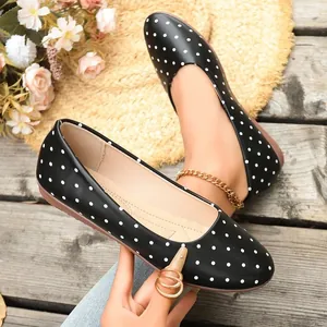 Vista dettagliata di eleganti ballerine nere da donna con raffinati pois bianchi