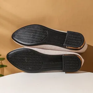 Detailed view of women's flat shoes featuring textured non-slip outsoles and golden heel accents.